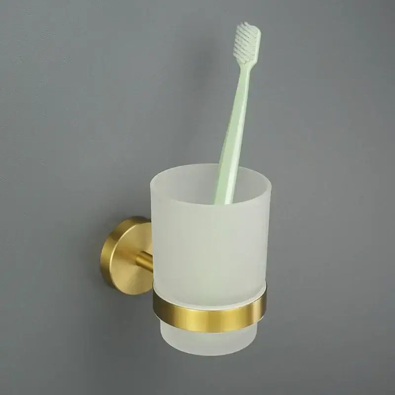 Modern brushed gold bathroom set featuring a gold-accented frosted glass toothbrush holder with sleek design decorbites brushed gold