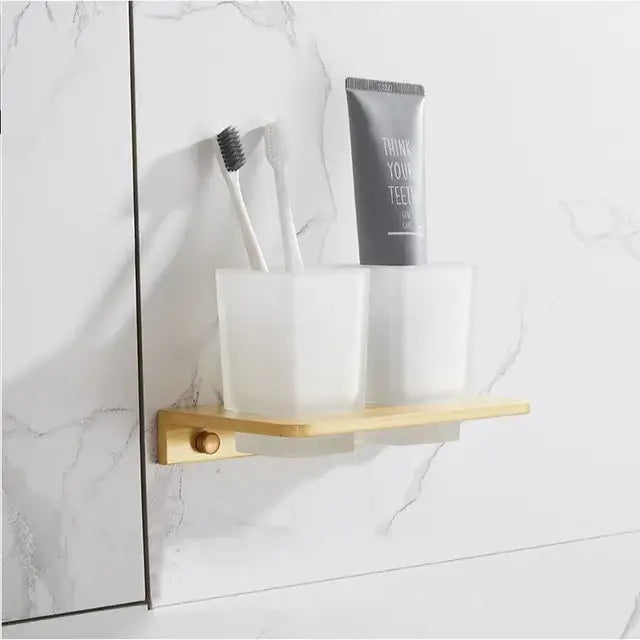 Minimalist wall-mounted toothbrush holder with two frosted glass cups and brushed gold metal base from decorbites bathroom set