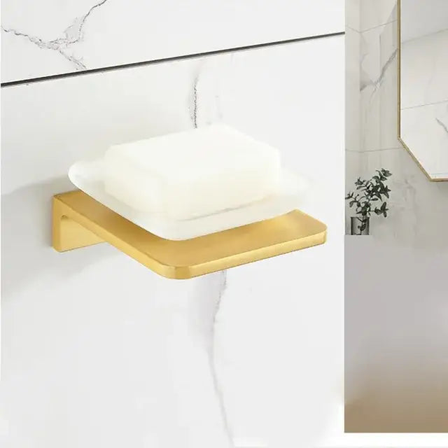 Gold-toned metal soap dish with sleek modern design holding white soap from decorbites brushed gold bathroom set