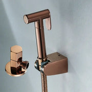 Modern brushed gold bidet sprayer kit featuring a rose gold bidet sprayer nozzle with matching wall-mounted bracket