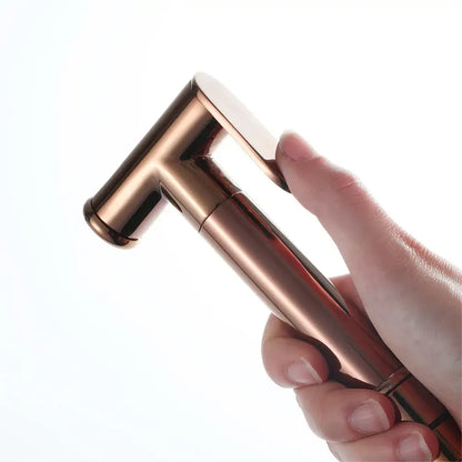 A sleek rose gold bidet sprayer kit with a modern minimalist design in brushed gold for bathroom use