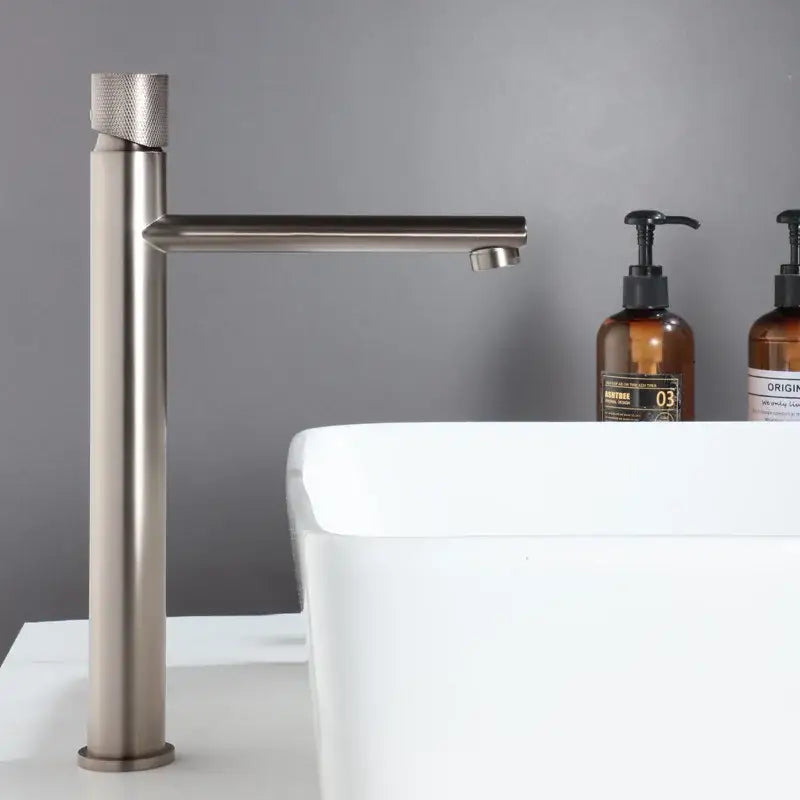 Modern brushed gold brass basin faucet with a textured cylindrical handle and sleek minimalist design for bathroom sink