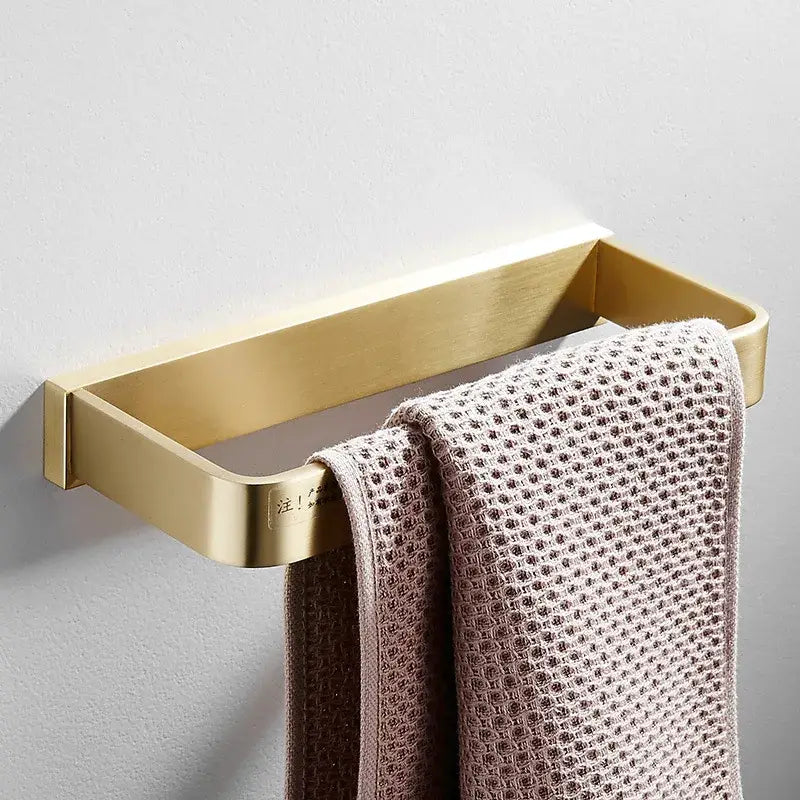 Modern brushed gold brass bath hardware set rectangular towel rack with matte finish holding two beige waffle towels