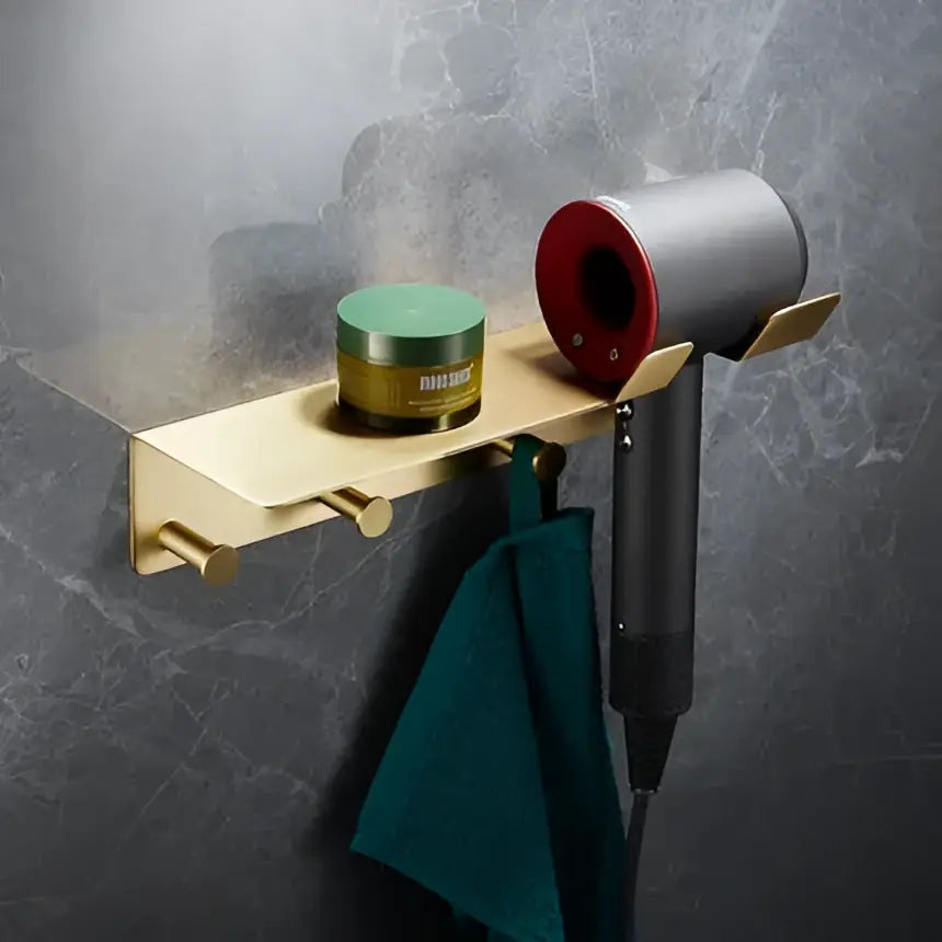 Modern brushed gold brass bath hardware set with wall-mounted hair dryer rack holding silver and red Dyson Supersonic