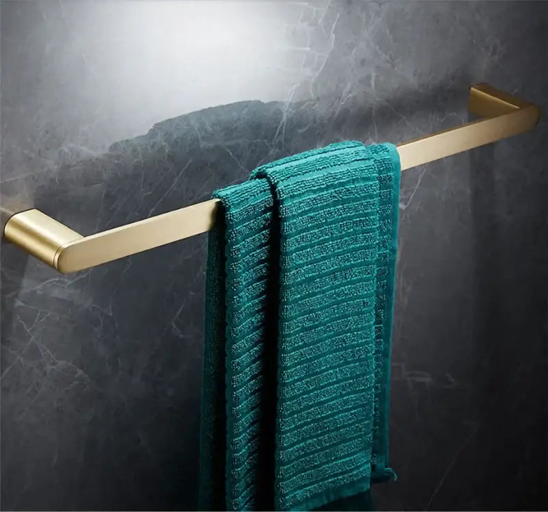 Modern brushed gold brass bath hardware set towel rack featuring a sleek gold-toned design with a plush teal towel