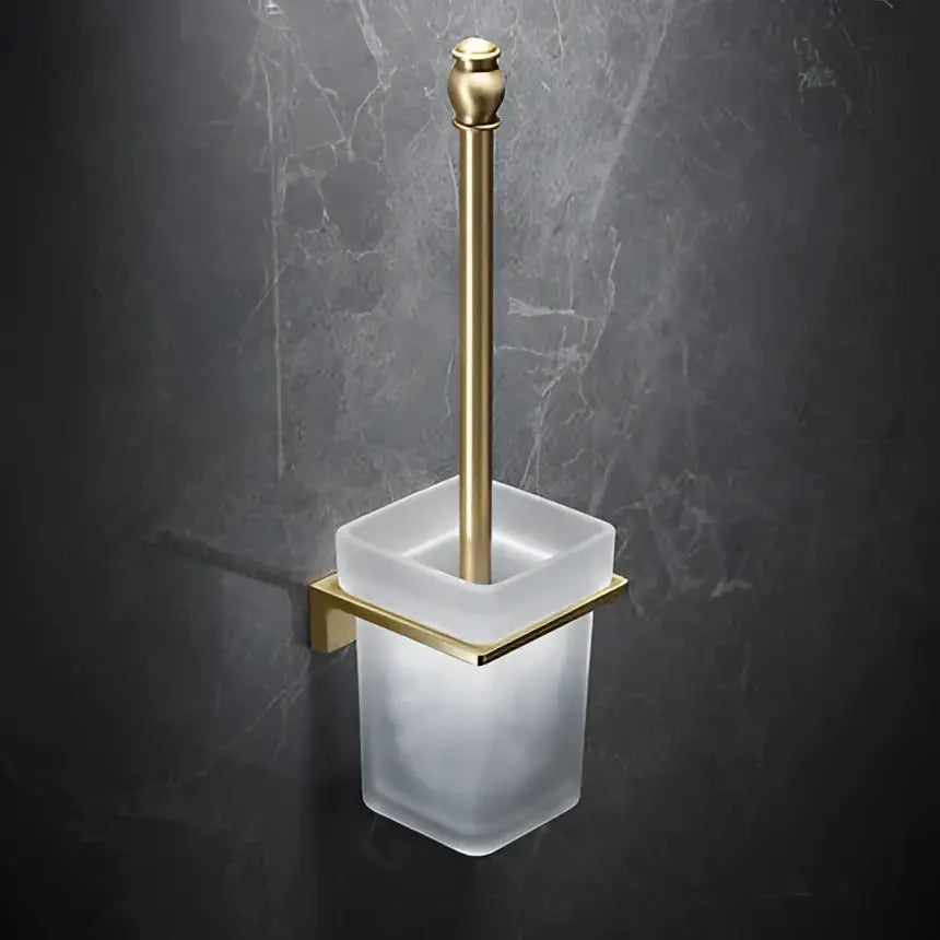 Modern brushed gold brass bath hardware set featuring a gold-toned toilet brush holder with frosted glass container and bracket