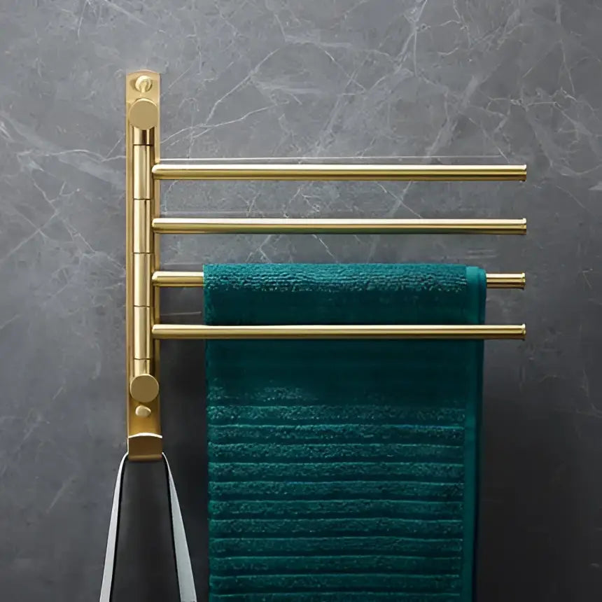 Modern brushed gold brass bath hardware set with a gold-toned four-bar towel rack holding a deep teal textured towel