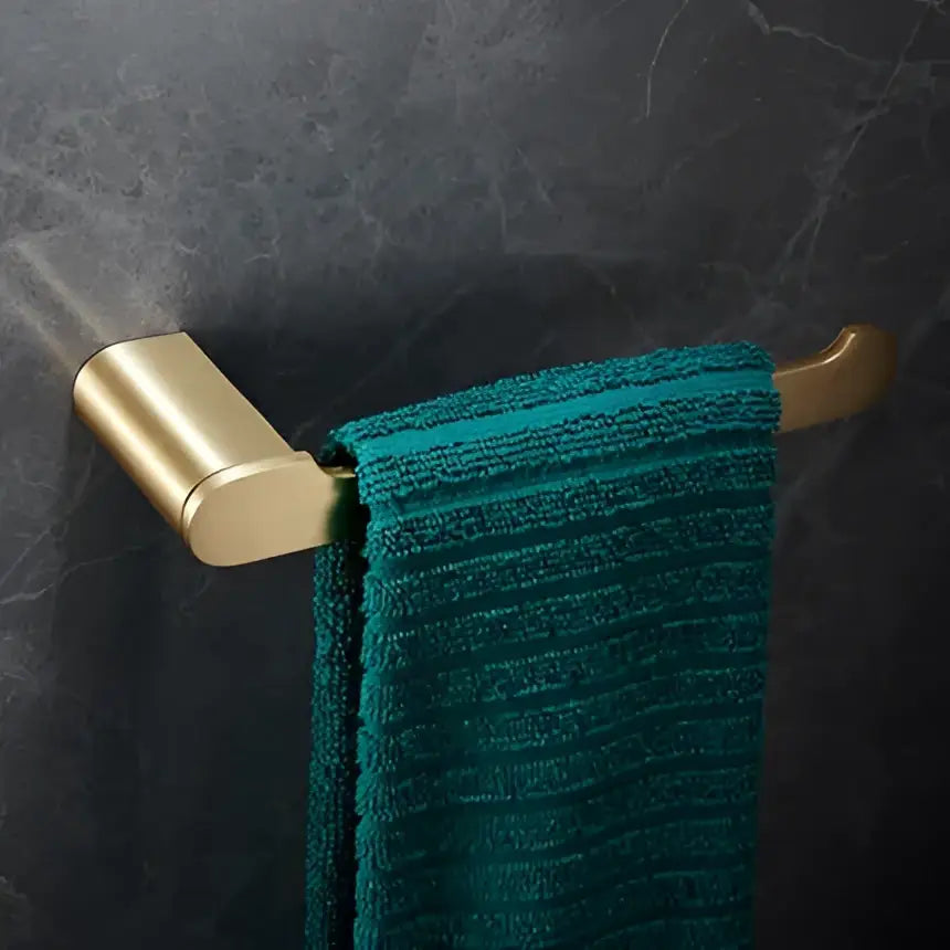 Modern brushed gold brass bath hardware set towel rack holding a teal textured towel for bathroom use