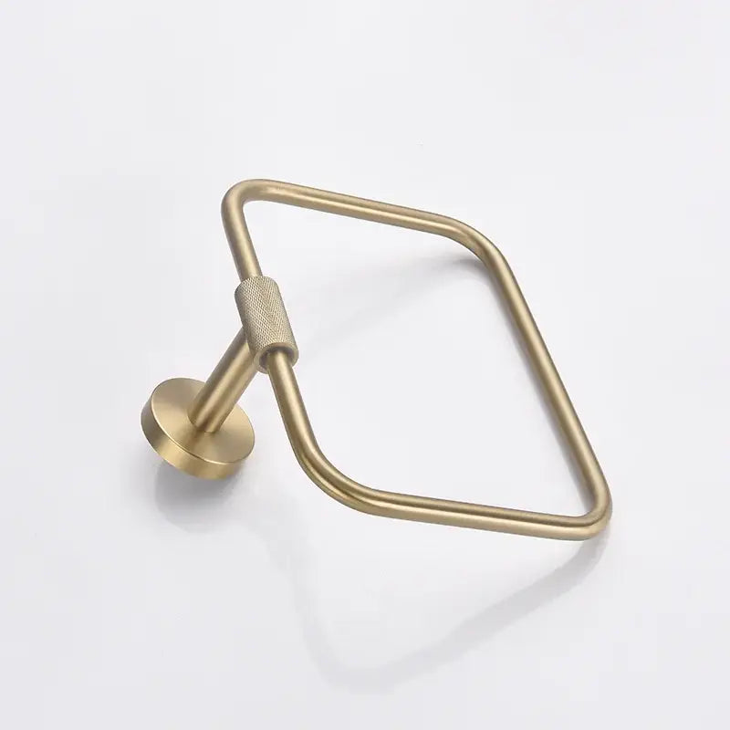 Brass-finished rectangular towel ring with textured grip on mounting stem in brushed gold bathroom accessories set