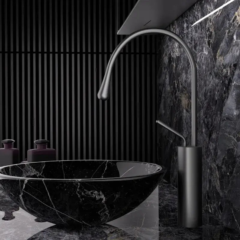 Black marble vessel sink paired with a modern brushed gold brass faucet featuring a sleek matte finish
