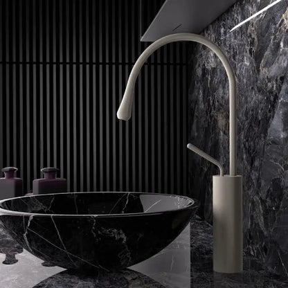 Modern white ceramic faucet with sleek curved spout in a brushed gold brass kitchen sink tap design