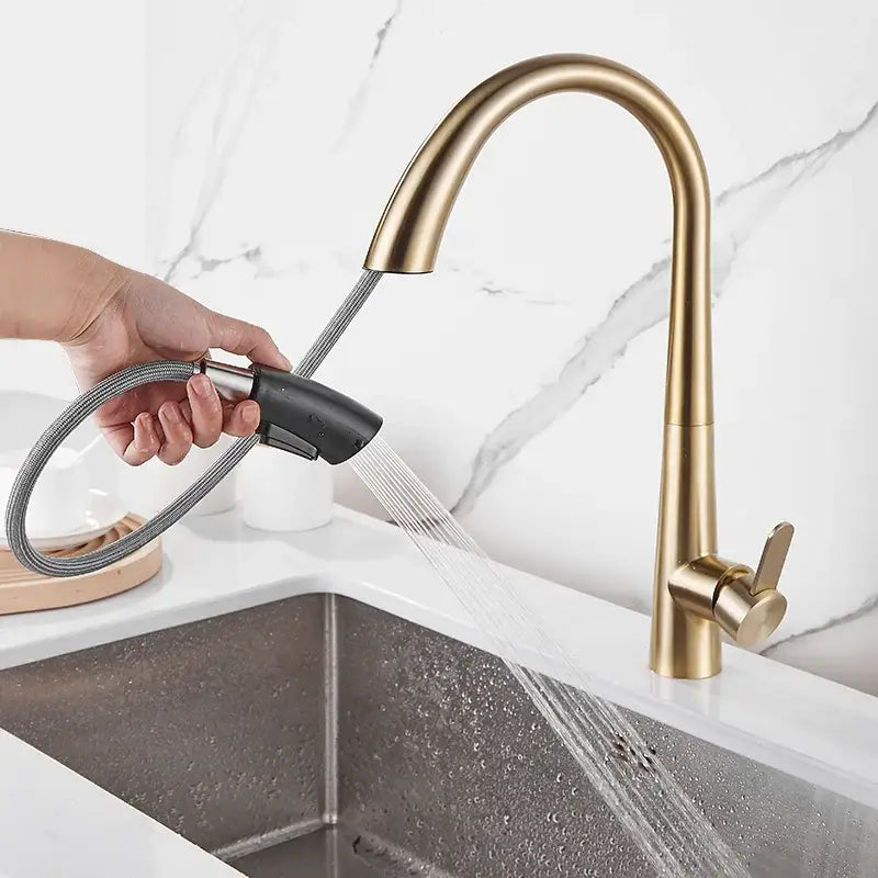 Modern brushed gold kitchen sink faucet with pull down curved spout and black handheld spray head for kitchen sink use
