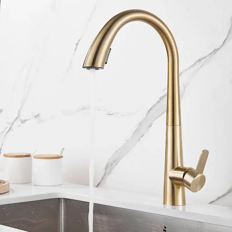 Modern brushed gold kitchen sink faucet with a sleek curved spout and pull-down spray head for kitchen sink use