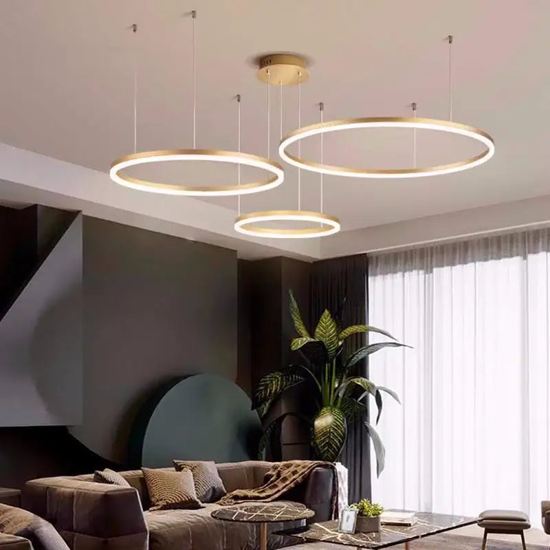 Three modern circular brushed gold led chandelier pendant lights with illuminated ring design for dining room decorbites