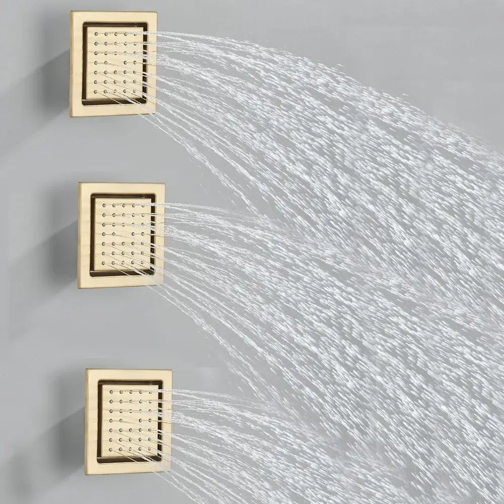 Three square brushed gold shower head panels with led spray patterns mounted vertically in bathroom set