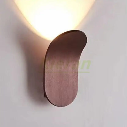 Modern brushed gold led wall lamp with warm-toned minimalist curved wooden sconce for living room illumination