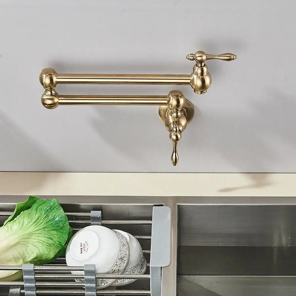 Brass-colored ornate wall-mounted modern brushed gold pot filler faucet with classic design and folding spout