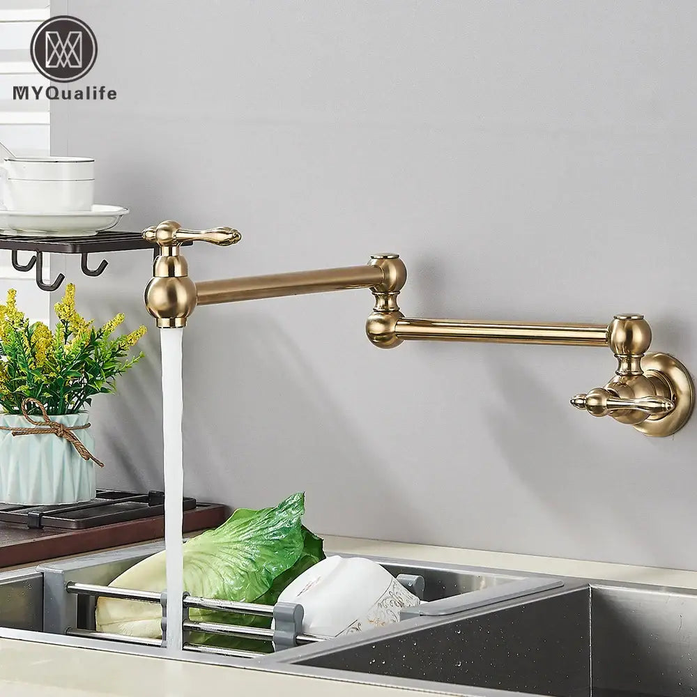 Modern brushed gold pot filler faucet with brass-colored extendable folding spout and ornate handles for kitchen use