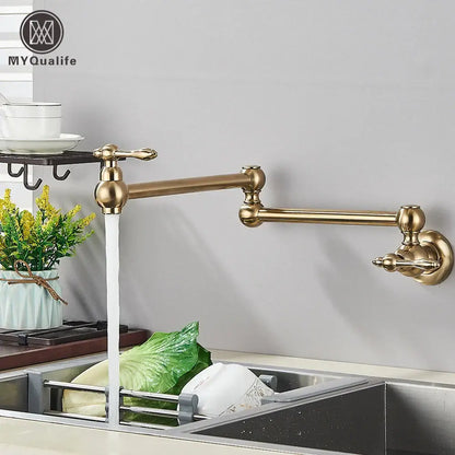 Modern brushed gold pot filler faucet with brass-colored extendable folding spout and ornate handles for kitchen use