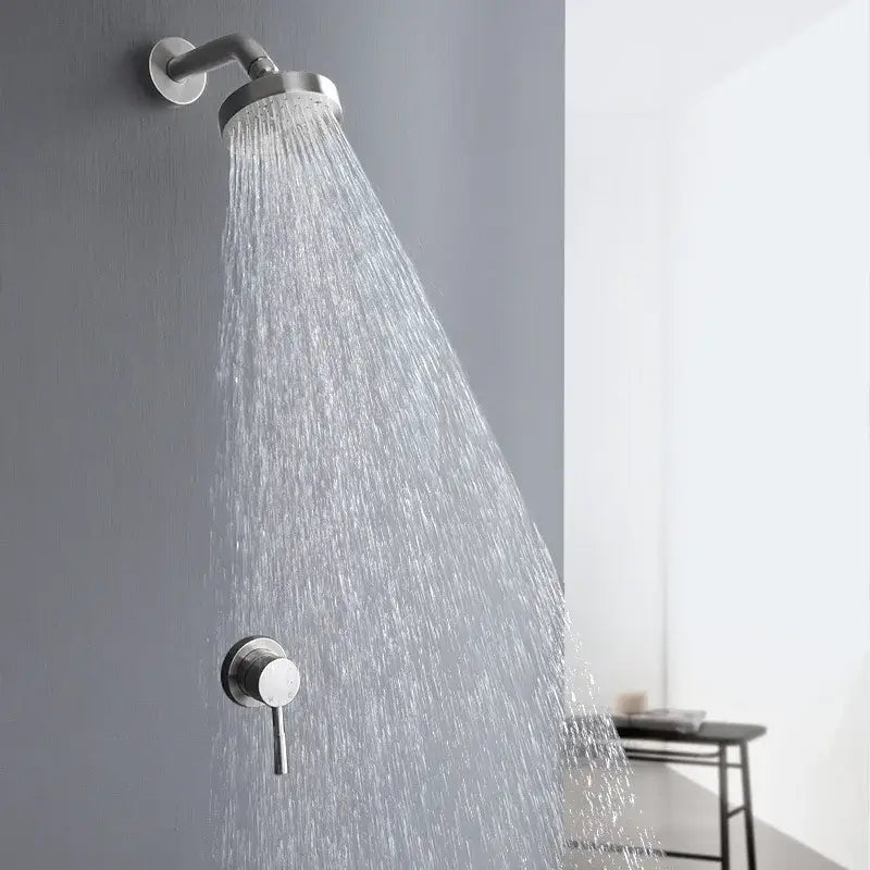 Modern chrome-finished rainfall showerhead with sleek design mounted on wall in brushed gold shower faucet set