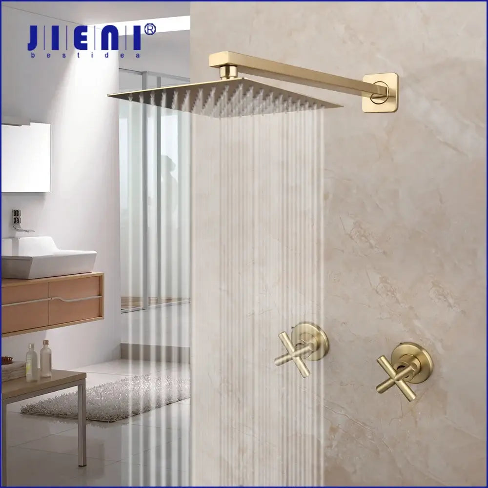 Modern brushed gold square rainfall shower set with gold-finished rain shower head and cross-handle faucets on tiled wall