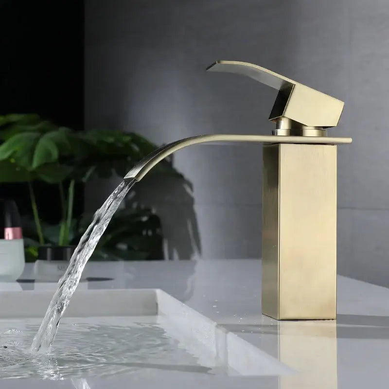 Modern brushed gold stainless steel basin faucet with sleek waterfall spout and rectangular minimalist base design