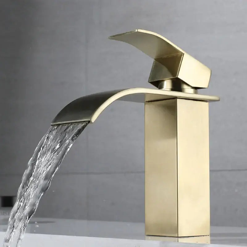 Modern brushed gold stainless steel basin faucet with sleek waterfall design and brushed metal finish for bathroom