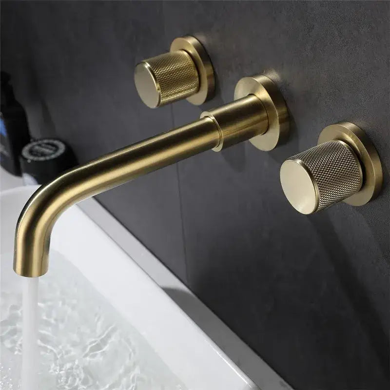 Modern brushed gold wall mount faucet with brass finish and textured cylindrical handles for bathroom use
