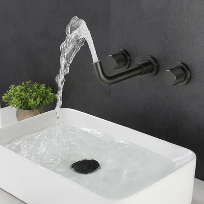 Modern brushed gold wall mount faucet with textured handles and curved spout pouring water into white rectangular sink