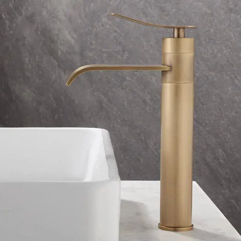 A sleek, tall modern brushed gold basin mixer with minimalist curved spout for decorbites bronze bathroom sink
