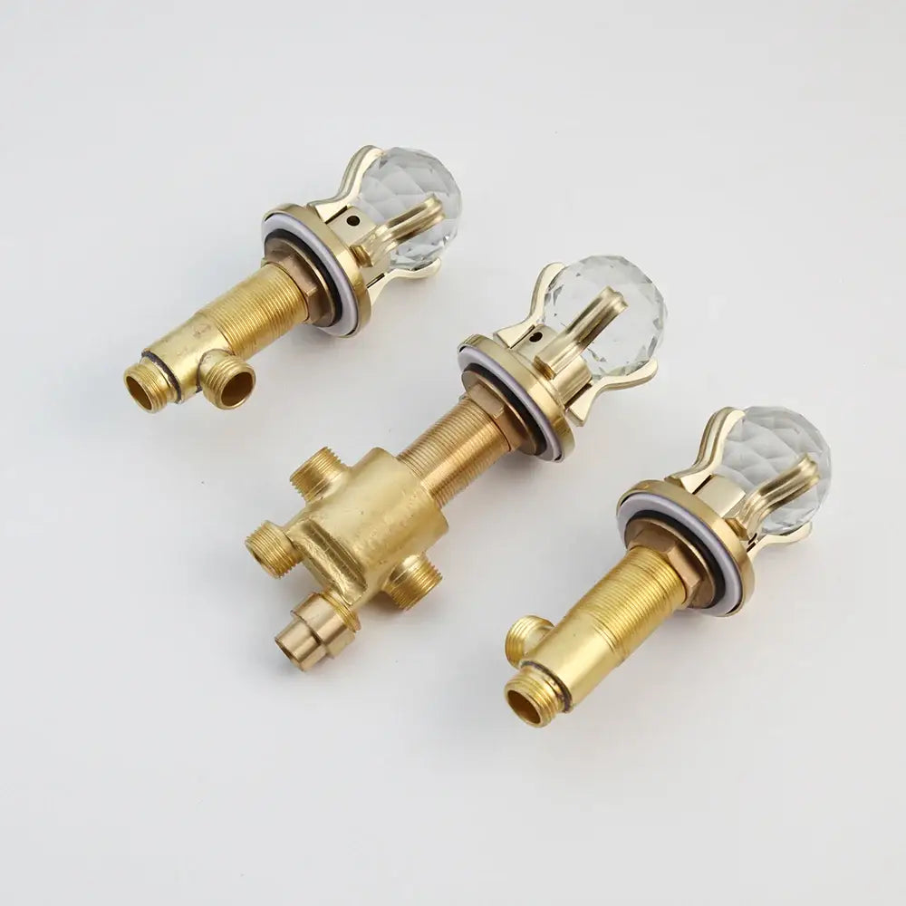 Three brass-finished waterfall shower faucet handles with faceted crystal knobs for wall mounted single handle use