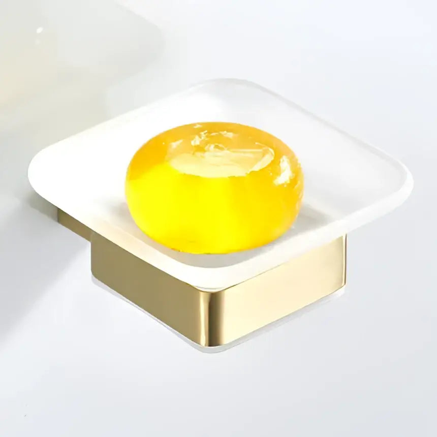 A translucent yellow soap in a modern white and gold-toned square soap dish from the decorbites bath set