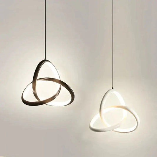 Modern brushed metal and white led bedside pendant light with interlocking circular rings emitting soft glow decorbites led bedside