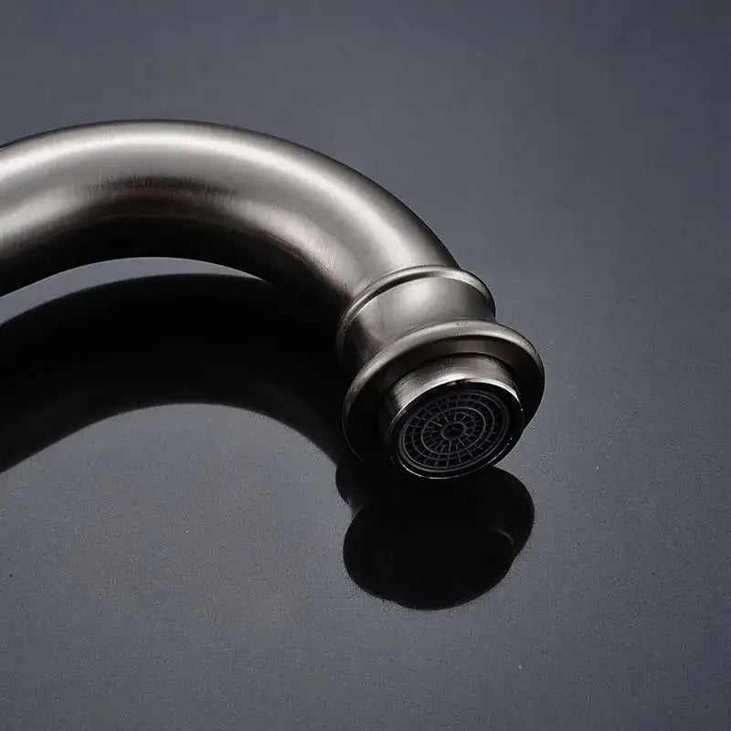 Modern brushed nickel basin faucet with long curved spout and circular spray head for bathroom use