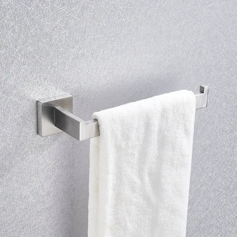A sleek brushed nickel towel rack with a white terry cloth towel from a modern bathroom hardware set