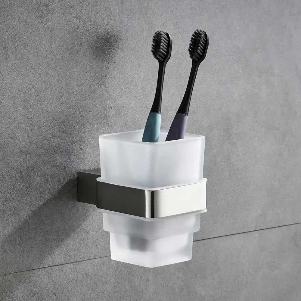Modern frosted glass toothbrush holder with sleek brushed nickel bracket holding two black-bristled toothbrushes in bathroom hardware set