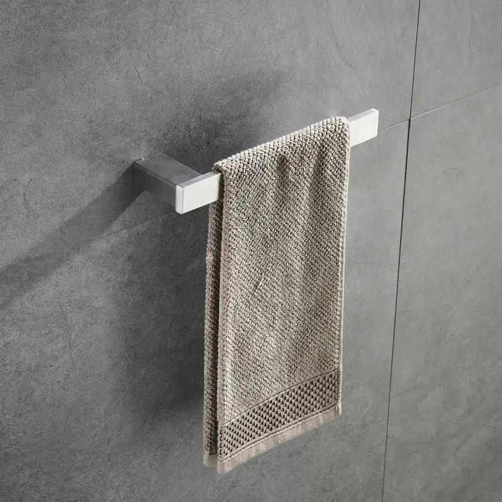 Modern brushed nickel bathroom hardware set with glass accents holding a beige textured towel on a chrome rack
