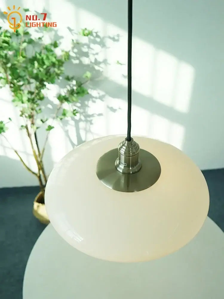 Modern brushed nickel glass pendant light with frosted white shade and black cord for kitchen indoor lighting