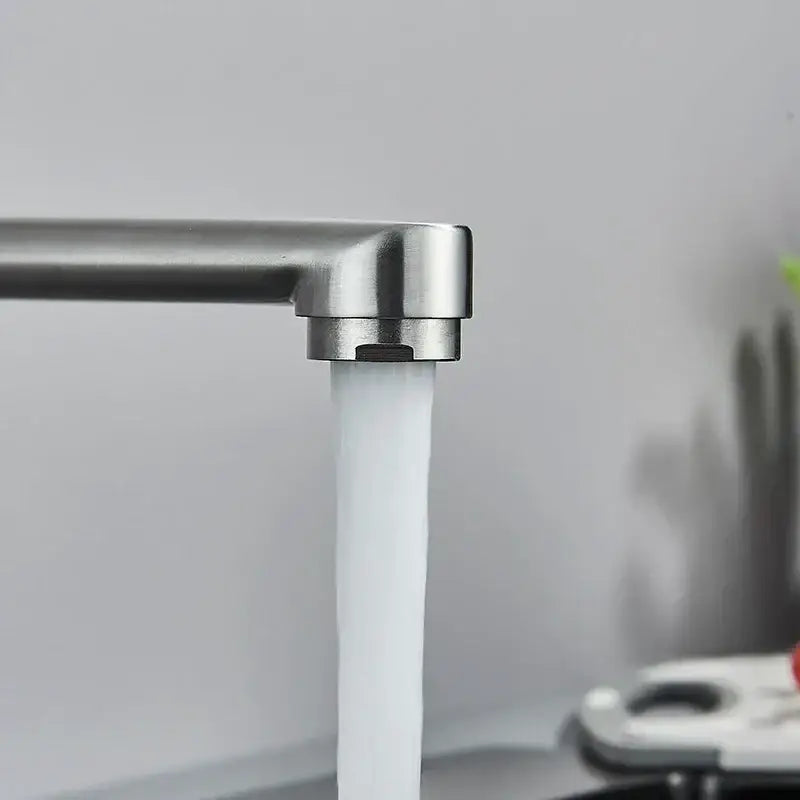 A sleek modern brushed nickel kitchen faucet wall mounted single lever mixer with a steady stream of clear water