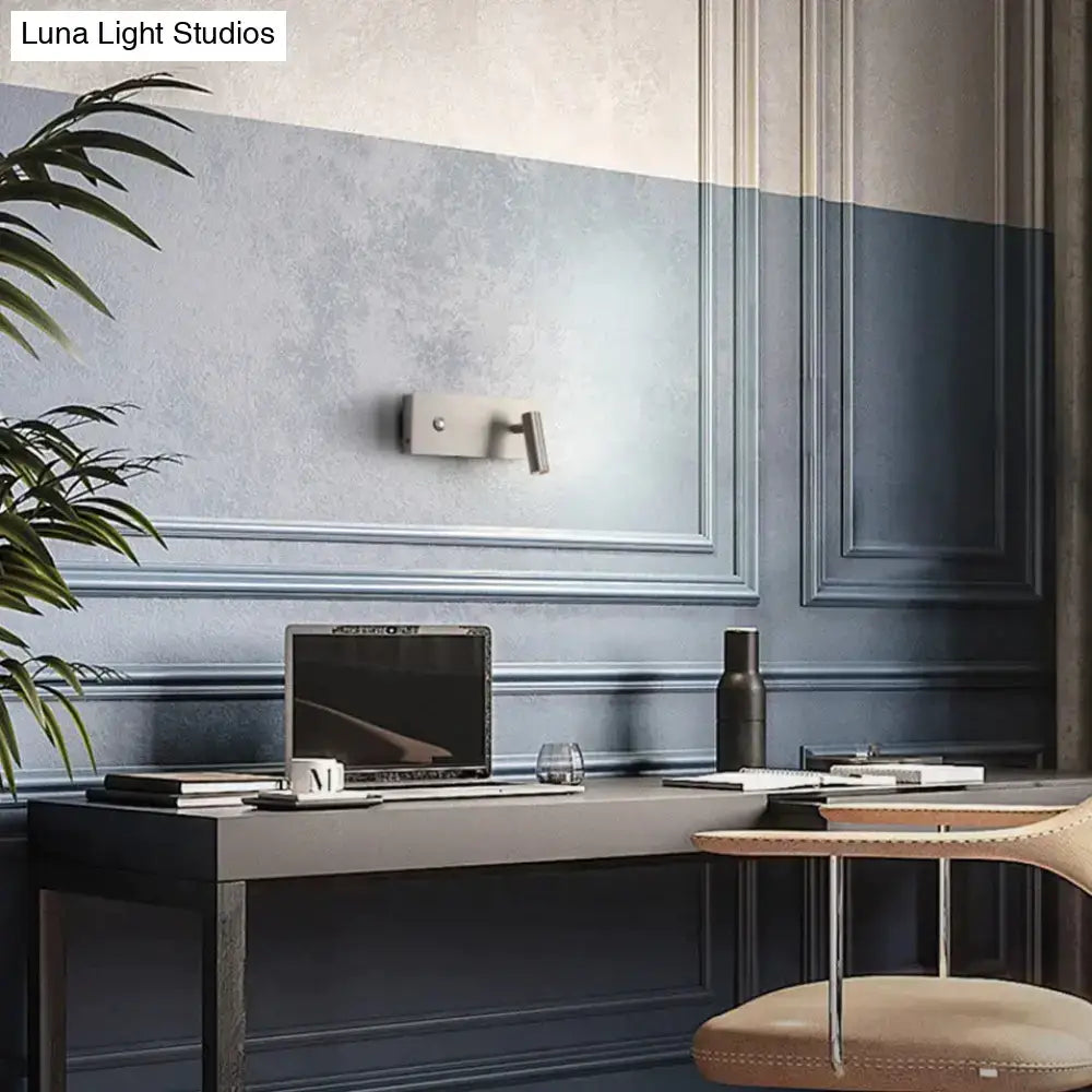 A sleek silver laptop on a dark gray desk beside a modern brushed nickel led dimmable reading wall light bedroom
