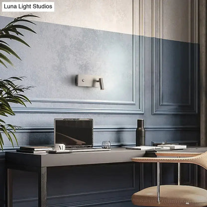 A sleek silver laptop on a dark gray desk beside a modern brushed nickel led dimmable reading wall light bedroom