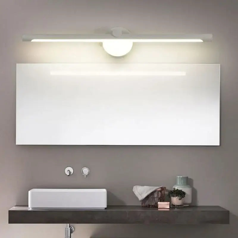 Modern brushed nickel led wall lamp with motion sensor above a sleek white rectangular bathroom mirror with minimalist design