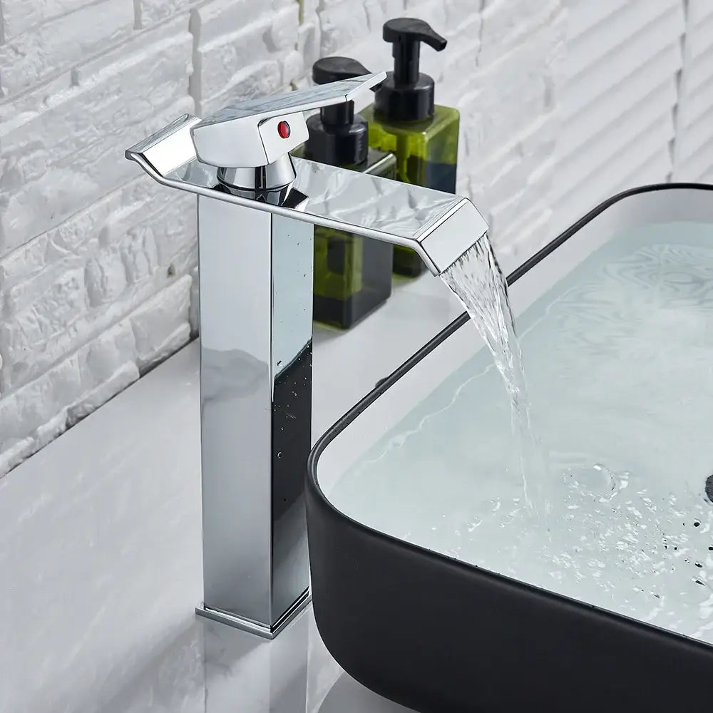 Modern brushed nickel basin faucet with single lever and chrome waterfall spout featuring a red indicator light