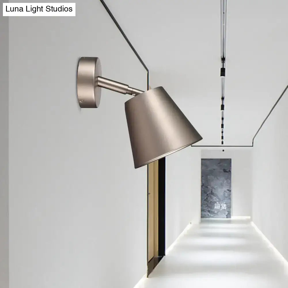 Modern brushed brass wall sconce with adjustable arm and conical shade is a sleek tapered wall light for bathrooms