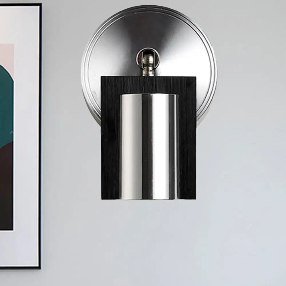 Modern brushed nickel and wood wall sconce with cylindrical metal shade and warm white light for bedroom use