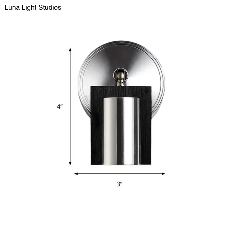 Modern brushed nickel and wood wall sconce with metal shade and warm white light for bedroom use