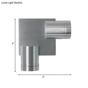 Modern brushed silver l-shaped wall light fixture with a 3-inch square base and cylindrical arms for bedroom use