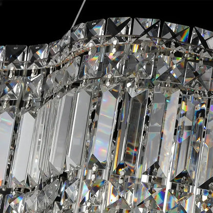 A modern brushed stainless crystal pendant light with cascading tiers of faceted prisms for dining room use