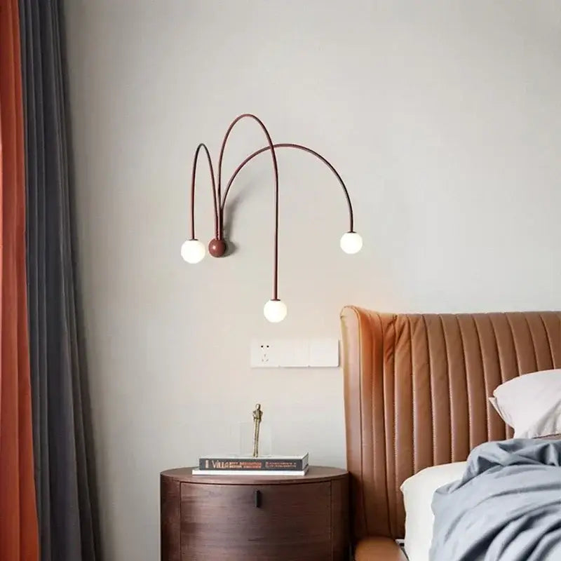 Modern bronze-toned wall light with three curved arms and white bulbs featuring decorbites iron glass led design
