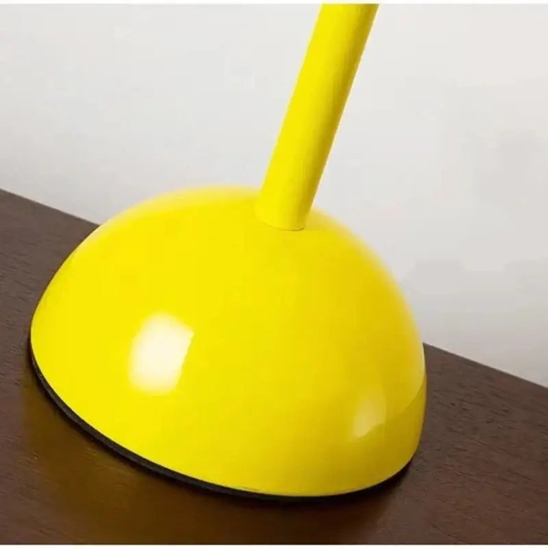 Bright yellow glossy plastic plunger with a smooth dome head next to modern burgundy iron mushroom shape macaron table lamp decorbites iron mushroom